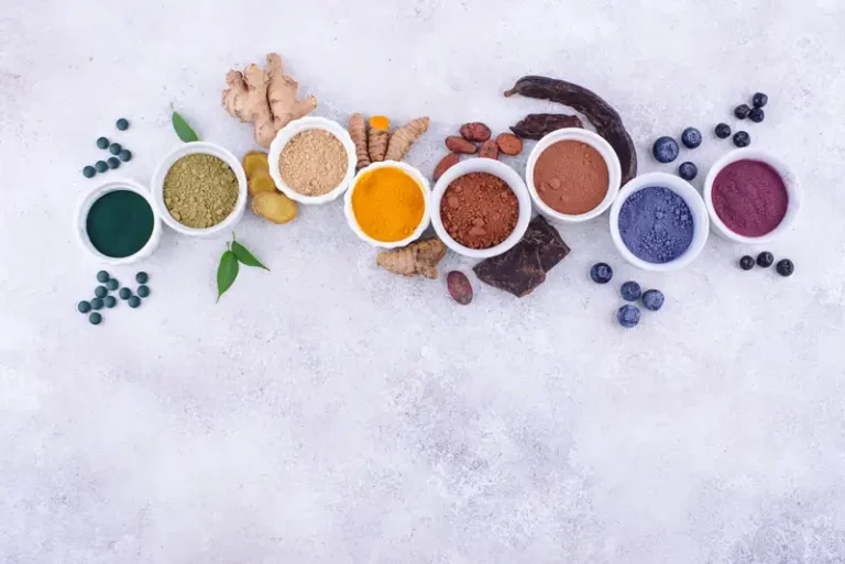 Aneka bubuk superfood berwarna alami dalam mangkuk kayu, tersusun rapi sebagai bahan pewarna makanan sehat.
