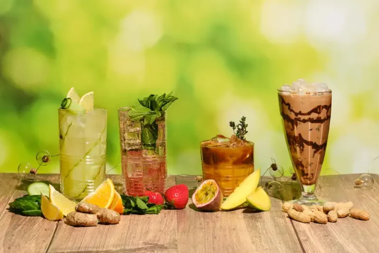 Aneka minuman dingin segar dalam gelas di atas meja kayu, cocok menggambarkan tren minuman populer.