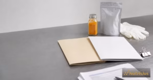 Dua map registrasi BPOM TR dan SD di meja bersih, berdampingan dengan pouch minuman serbuk dan botol bumbu.
